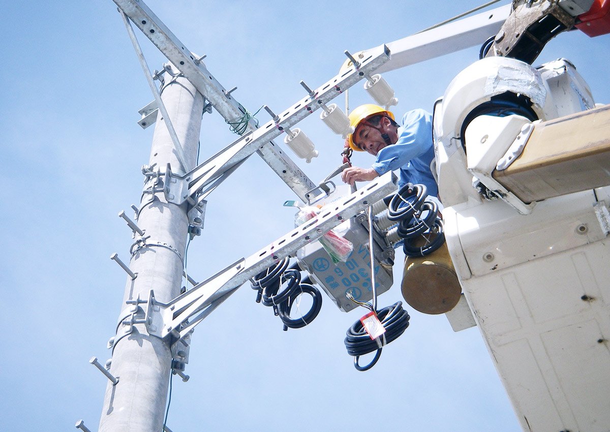 栄電業株式会社の業務イメージ 電柱での高所作業をする電気工事スタッフ